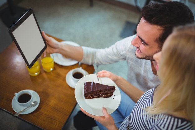 Smiling couple taking selfie from digital tablet