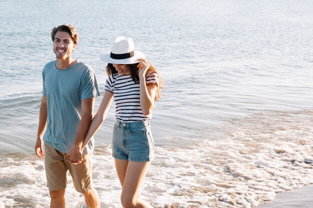 海岸で歩く笑顔のカップル