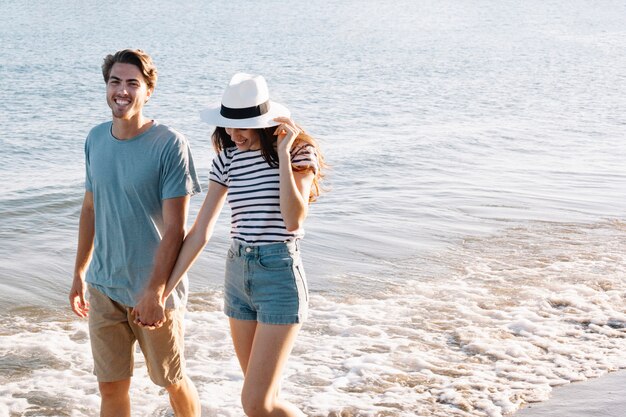 Smiling couple walking at the shoreline