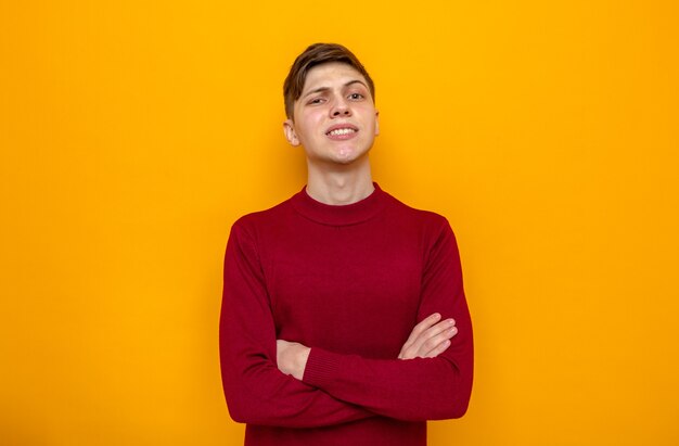 Smiling crossing hands young handsome guy wearing red sweater 