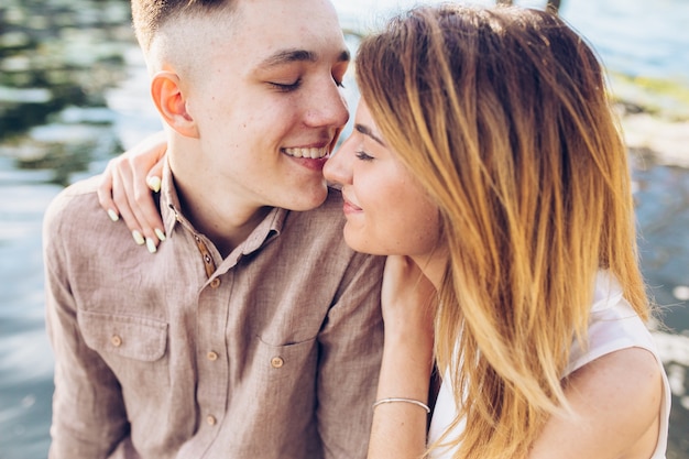 Smiling cuddling couple at water