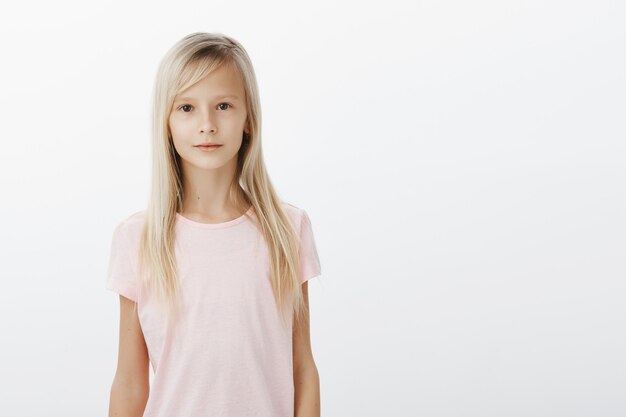 Smiling cute girl looking at camera over white background