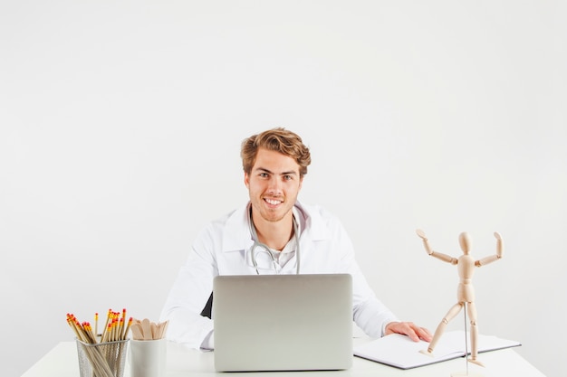 Foto gratuita medico sorridente alla scrivania