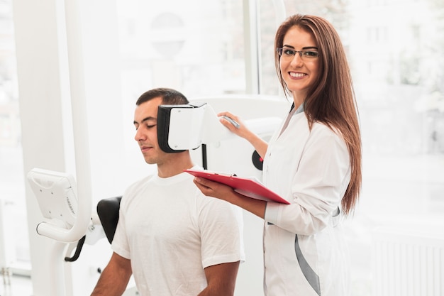 Free photo smiling doctor holding clipboard checking patient