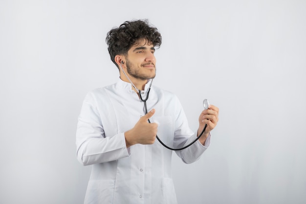 Smiling doctor holding stethoscope and ready to check patient.