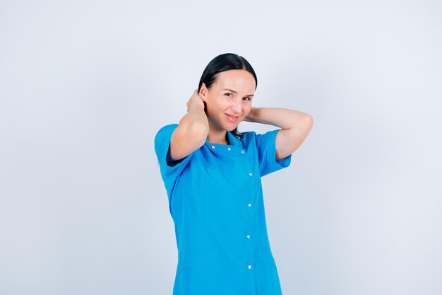 Smiling doctor is looking at camera by holding hair on white background