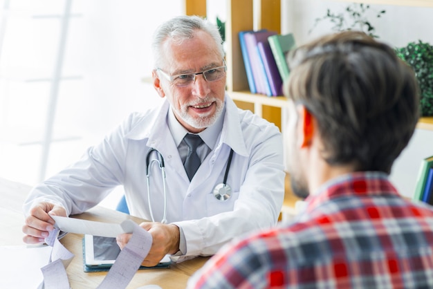 Smiling doctor listening to patient