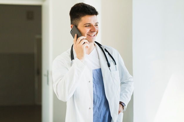 Smiling doctor making phone call