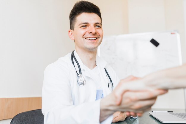 Smiling doctor shaking hand