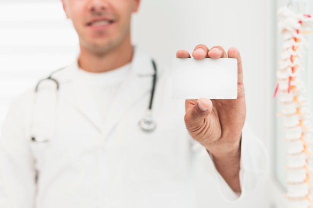 Free photo smiling doctor showing card mock up