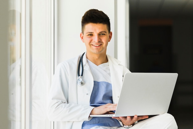 Smiling doctor with laptop