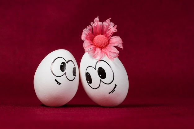 Smiling eggs on burgundy background