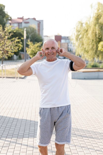 Smiling elder listening to music medium shot