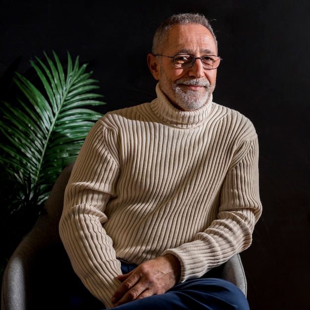 Smiling elderly male near plant