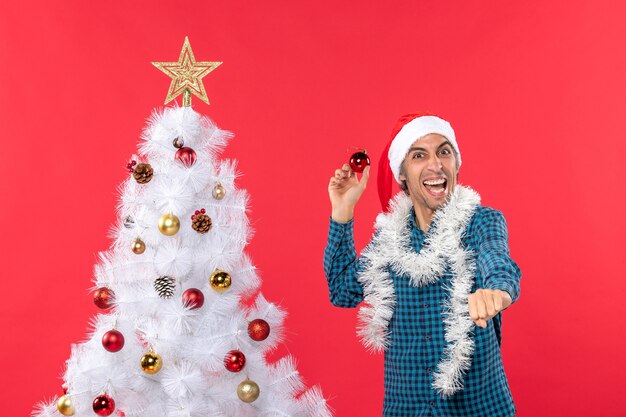 Smiling emotional funny excited confident young man with santa claus hat in a blue stripped shirt