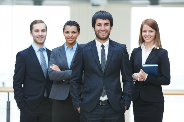 Smiling executives with male leader in front