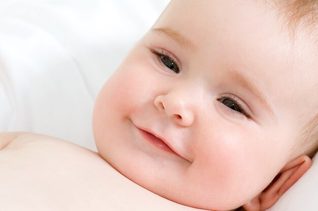 улыбающееся лицо красивой новорожденной девочки