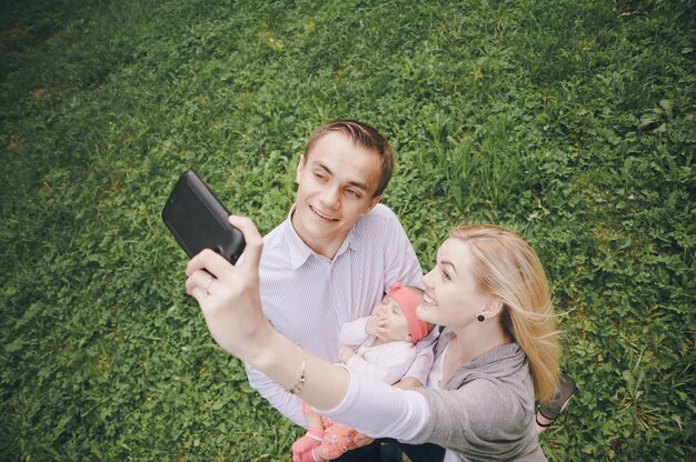 Smiling family taking a photo outdoors