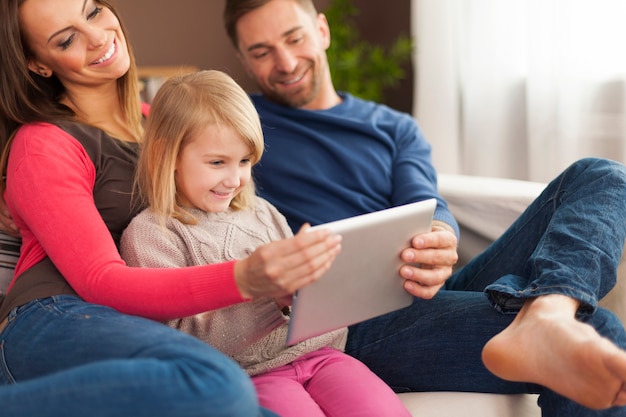 집에서 디지털 태블릿을 사용하여 웃는 가족