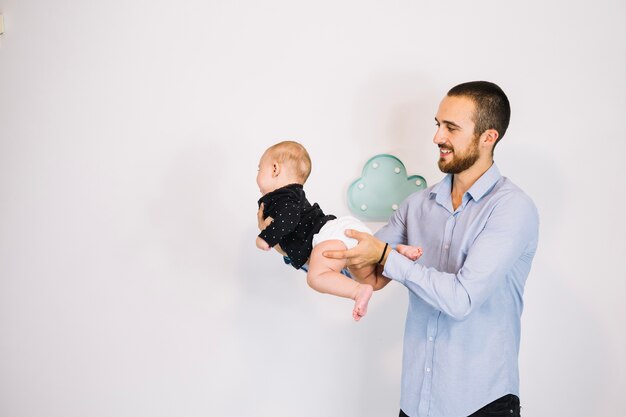 Smiling father playing with baby