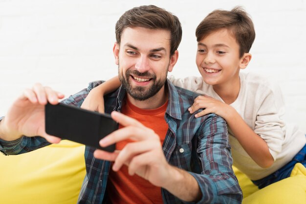 Smiling father and son taking selfies