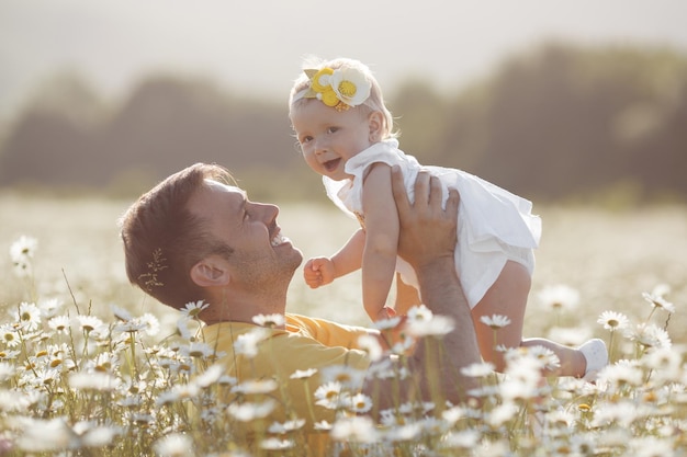 Free photo smiling father with cute baby girl outdoor in camomile field