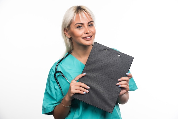 白い背景の上のクリップボードを保持している笑顔の女性医師。高品質の写真