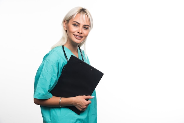 Smiling female doctor holding a clipboard on white background. High quality photo
