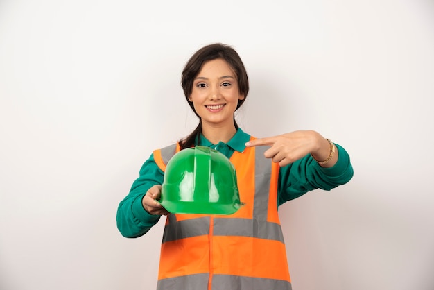 Free photo smiling female engineer holding a helmet on white background.