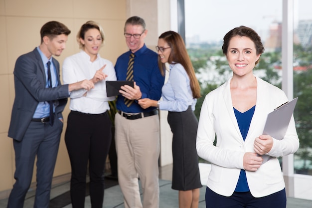 Smiling Female Executive Standing in Front of Team
