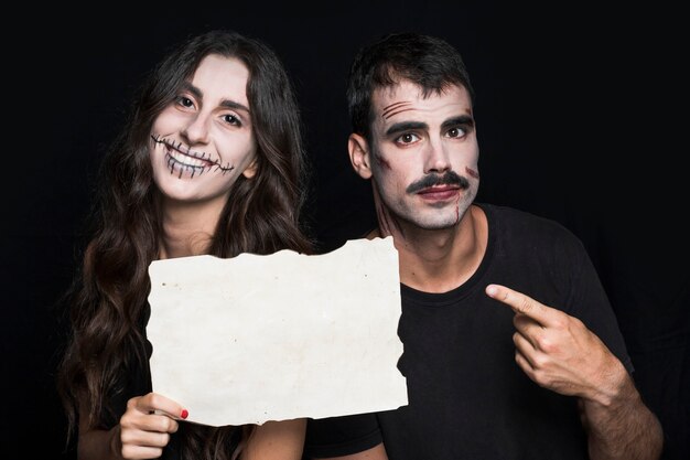 Smiling female and handsome man holding paper sheet