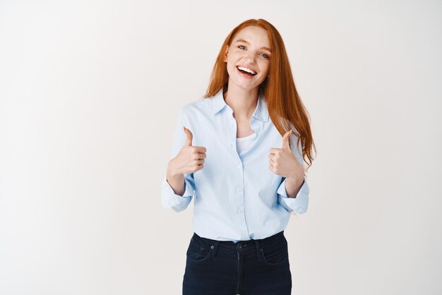 Smiling female hr manager showing thumbsup in approval telling yes recommending special promo deal white background