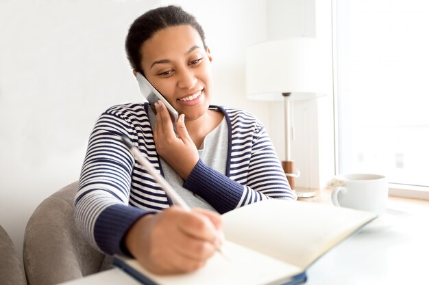 Smiling female manager talking to client on phone