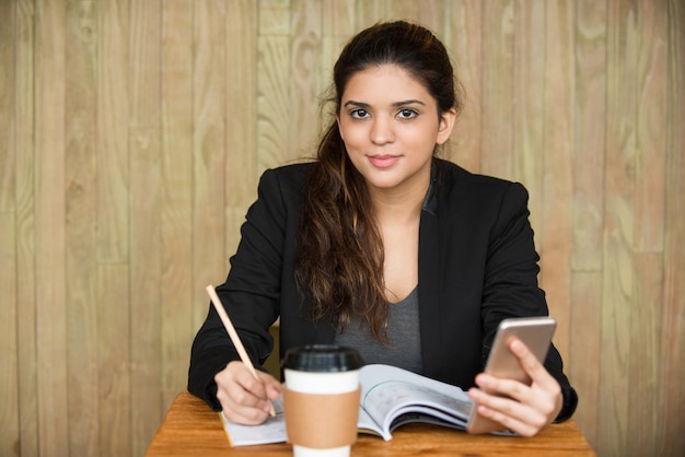 Free photo smiling female student doing homework at desk