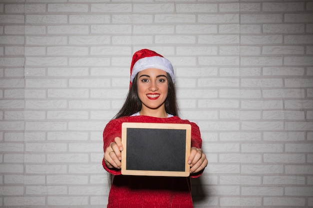 Smiling festive woman with blackboard 