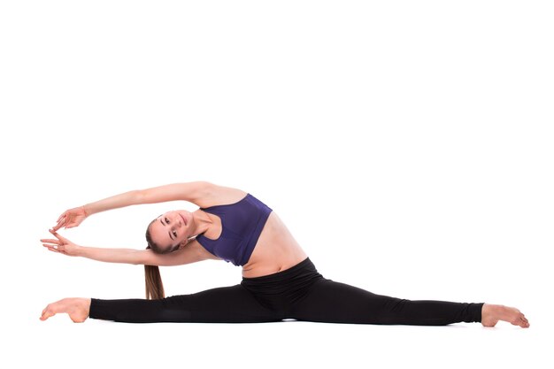 Smiling fitness woman sitting on a twine in a white background