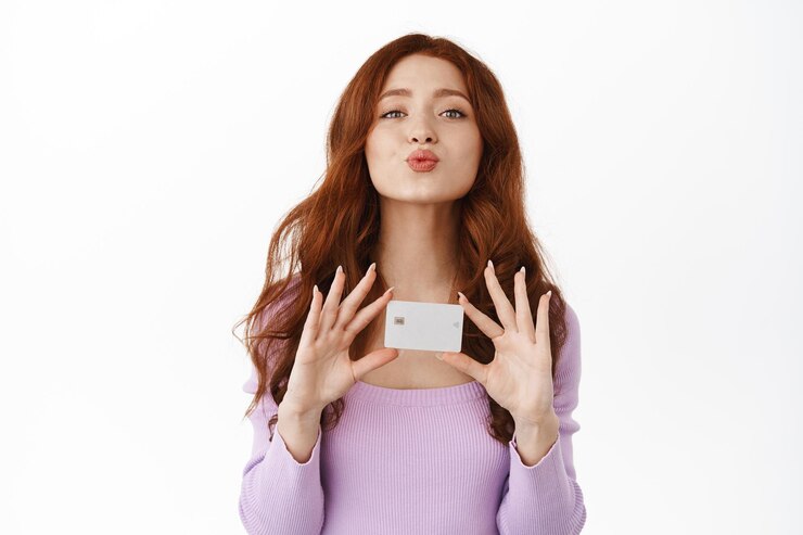 Free Photo smiling flirty redhead girl pucker lips, kissing and showing credit card, buying something, going shopping, standing in purple blouse against white background