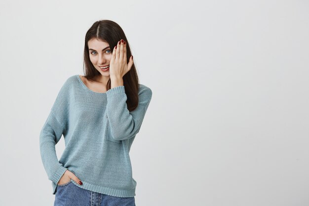 Smiling flirty woman showing hand with manicure