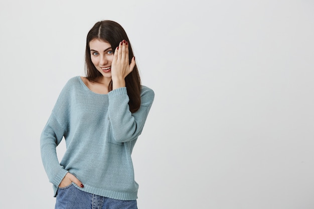 Smiling flirty woman showing hand with manicure