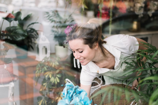 Smiling florist arranging shop-window