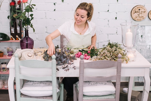 Smiling florist making bouquets