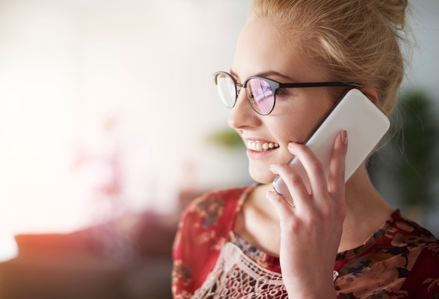 Smiling freelancer talking by mobile phone