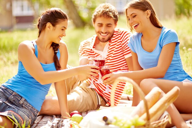 Smiling friends having picnic on a sunny day