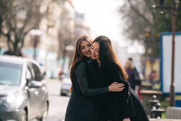 Smiling friends hugging each other