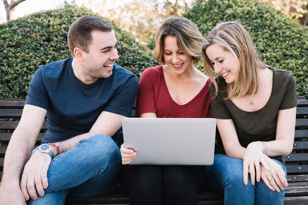 Smiling friends looking at laptop