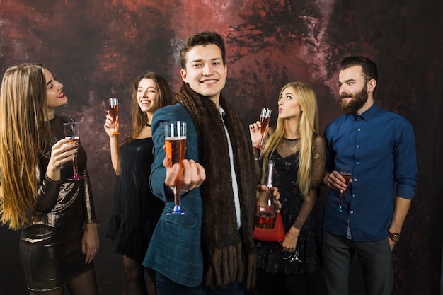 Free photo smiling friends showing champagne glasses