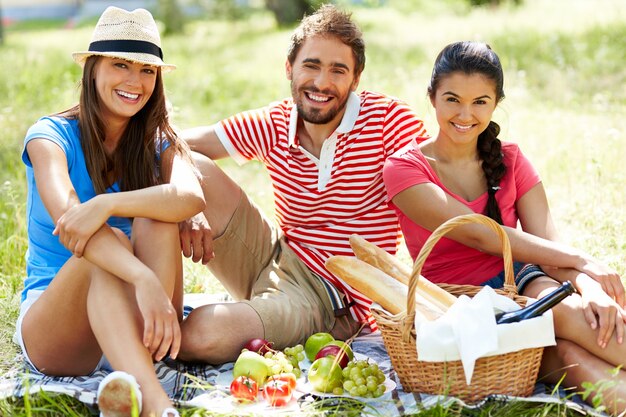 Smiling friends sitting on the grass