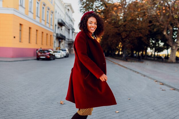 Smiling girl in amazing winter outfit and accessories posing on street