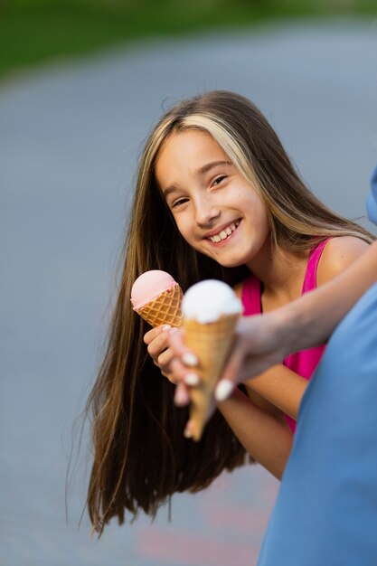 Улыбающаяся девушка ест мороженое
