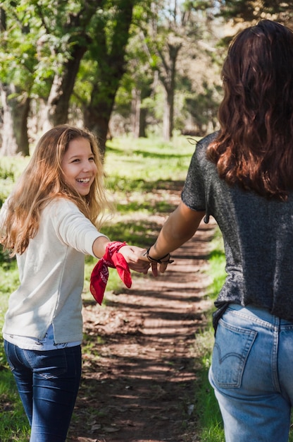 Ragazza sorridente che tiene la sua mano delle sorelle più anziane